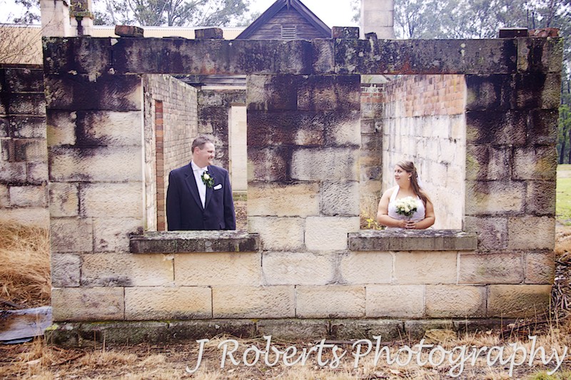 Bride and groom in windows of sandstone facade - wedding photography sydney